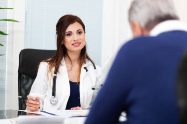 Doktor hastasıyla birlikte radyografiyi inceliyor.