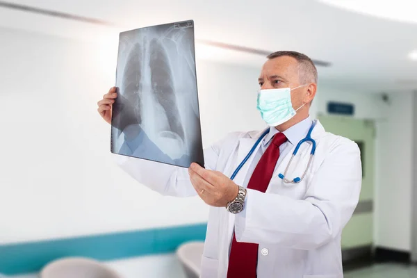 Médico Usando Uma Máscara Enquanto Segurava Uma Radiografia Pulmonar Coronavírus — Fotografia de Stock