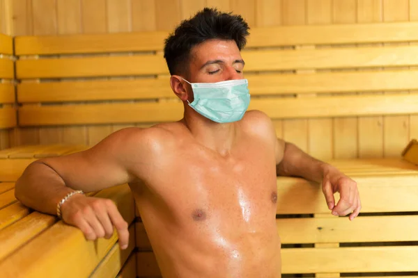 Mężczyzna Relaksujący Się Saunie Masce Koncepcja Pandemii Koronawirusowej — Zdjęcie stockowe