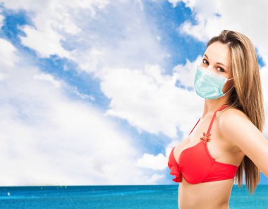 Coronavirus salgını sırasında denizin önünde poz veren bir kadının portresi.