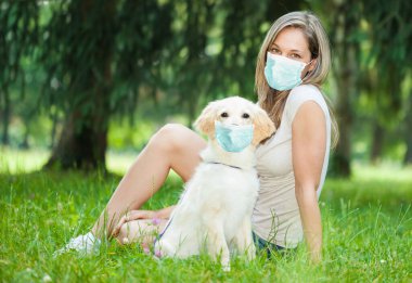 Genç bir kadın av köpeğiyle dışarıda oynuyor.