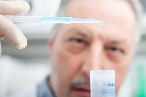 研究室に青い液体とフラスコを保持する男性研究者のクローズアップ肖像 コロナウイルス研究の概念 — ストック写真