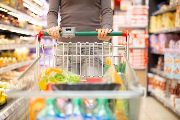 Woman pulling a shopping cart in a grocery store