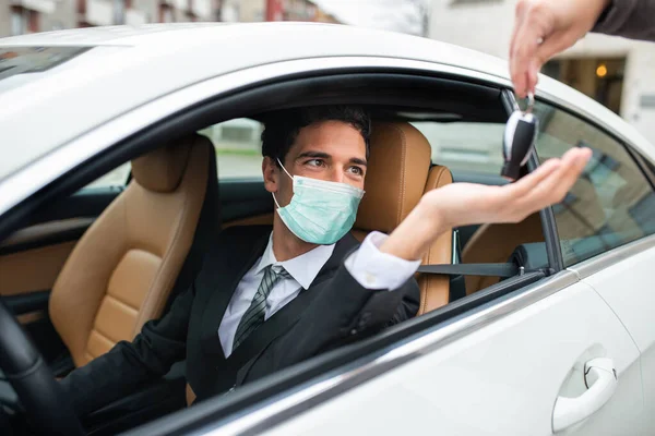 車のキーを取る仮面の男 自動車のコロナウイルスの概念 — ストック写真