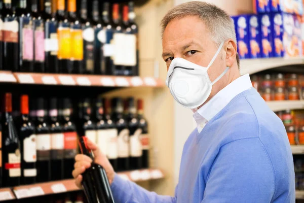 Человек Супермаркете Выбирает Бутылку Вина — стоковое фото
