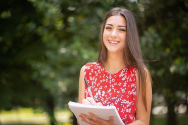 açık havada otururken okuyan kadın