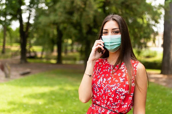 Mujer Joven Enmascarada Hablando Por Teléfono —  Fotos de Stock