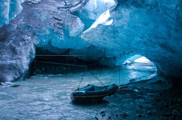 Loď v modrá ledová jeskyně pod ledovci na Islandu — Stock fotografie