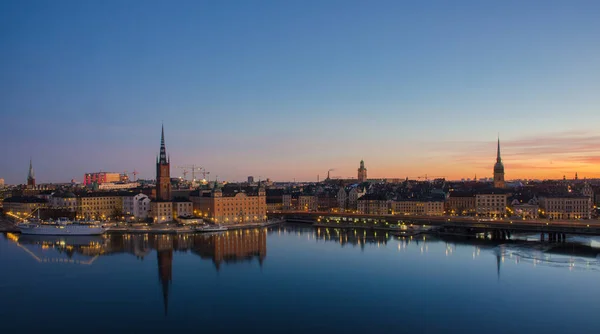 Vista panorámica de la ciudad de Estocolmo al amanecer, reflejada sobre el agua congelada . Imágenes De Stock Sin Royalties Gratis