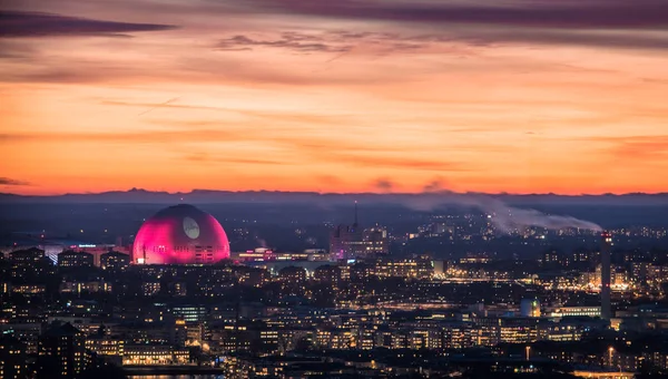 Edificio de arena Globe iluminado en rosa contra el cielo del atardecer durante la temporada navideña . Imágenes De Stock Sin Royalties Gratis