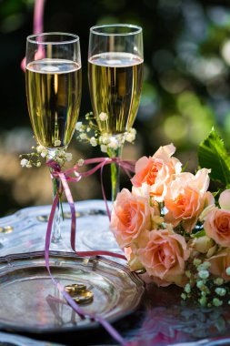 Alyans dekore edilmiş şampanya bardağı ve gül ile törenden önce