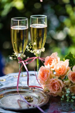Alyans dekore edilmiş şampanya bardağı ve gül ile törenden önce