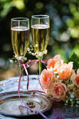 Alyans dekore edilmiş şampanya bardağı ve gül ile törenden önce