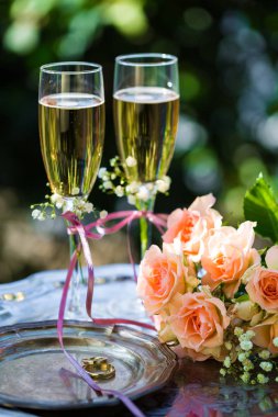 Alyans dekore edilmiş şampanya bardağı ve gül ile törenden önce