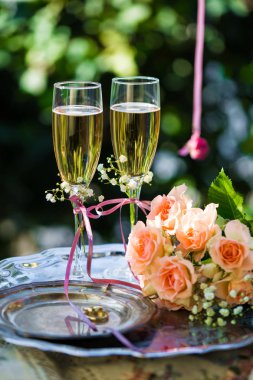 Alyans dekore edilmiş şampanya bardağı ve gül ile törenden önce