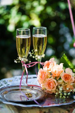 Alyans dekore edilmiş şampanya bardağı ve gül ile törenden önce