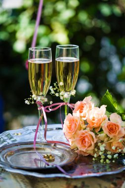 Alyans dekore edilmiş şampanya bardağı ve gül ile törenden önce