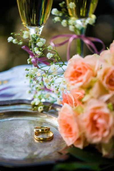 Anillos de boda antes de la ceremonia, con copas de champán decoradas y rosas — Foto de Stock
