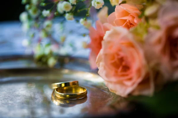 Trauringe vor der Trauung mit geschmückten Sektgläsern und Rosen — Stockfoto