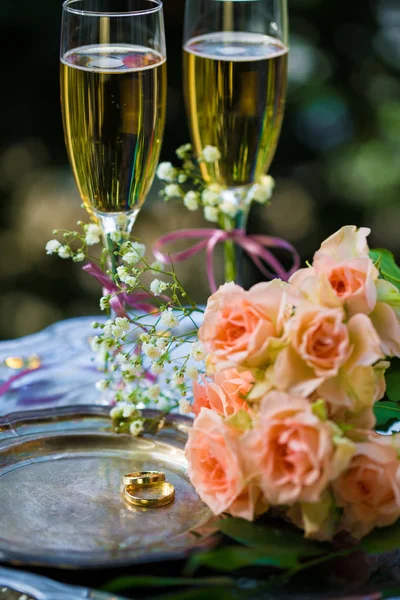 Anillos de boda antes de la ceremonia, con copas de champán decoradas y rosas —  Fotos de Stock