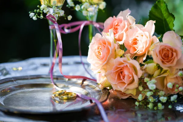 Trauringe vor der Trauung mit geschmückten Sektgläsern und Rosen — Stockfoto
