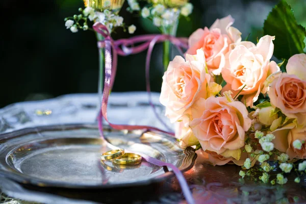 Trauringe vor der Trauung mit geschmückten Sektgläsern und Rosen — Stockfoto