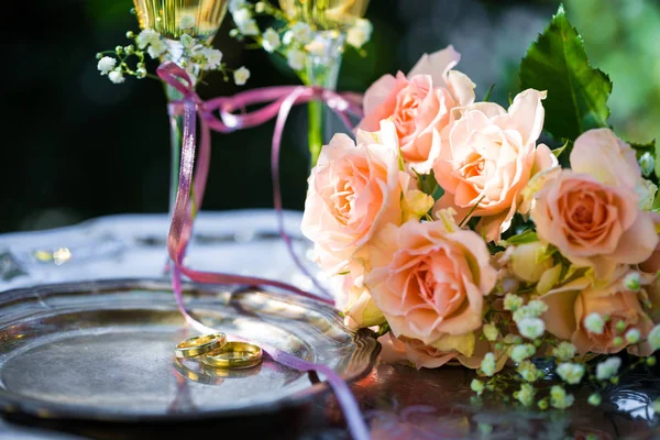 Trauringe vor der Trauung mit geschmückten Sektgläsern und Rosen — Stockfoto