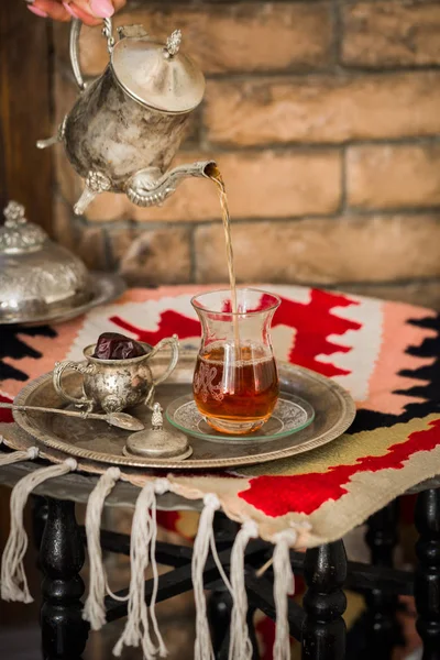 Чайний набір у східному стилі у склянці грушоподібної форми з вінтажним чайником і фініками фруктів — стокове фото