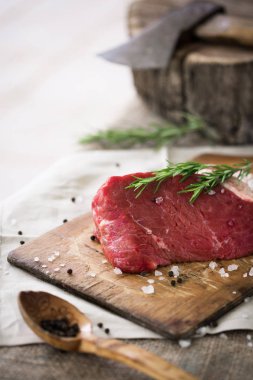 Ahşap kesme tahtası biberiye yaprağı ile ham sığır eti dilimleri