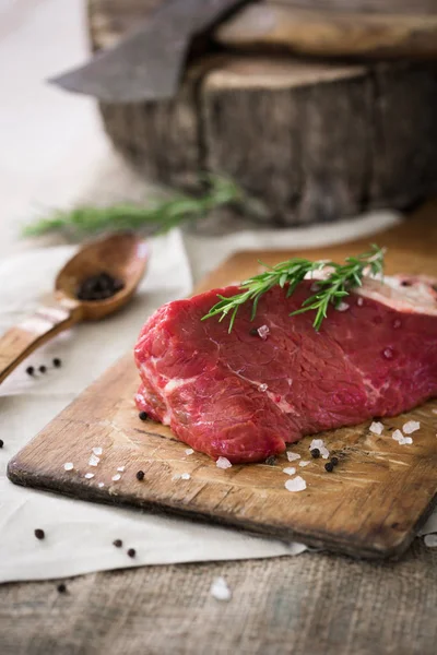 Ahşap kesme tahtası biberiye yaprağı ile ham sığır eti dilimleri