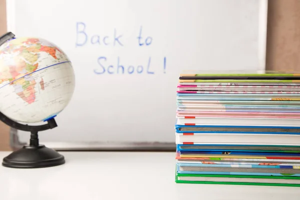 Mesa blanca con pila de libros coloridos, despertador y útiles escolares, espacio para copiar, tiempo de estudio de la educación en el hogar de los niños — Foto de Stock