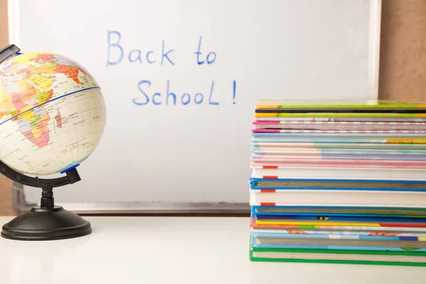 Masă albă cu stivă de cărți colorate, ceas deșteptător și consumabile școlare, spațiu de copiere, timp de studiu pentru copii acasă — Fotografie, imagine de stoc