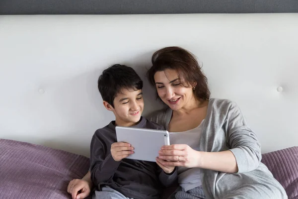 Mãe e filho tendo tempo de família feliz em casa assistindo a um filme em tablet, conceito de tempo de família acolhedor — Fotografia de Stock
