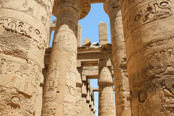 Hieróglifos e símbolos antigos nas colunas do Templo de Karnak, fileira de pilares em perspectiva — Fotografia de Stock