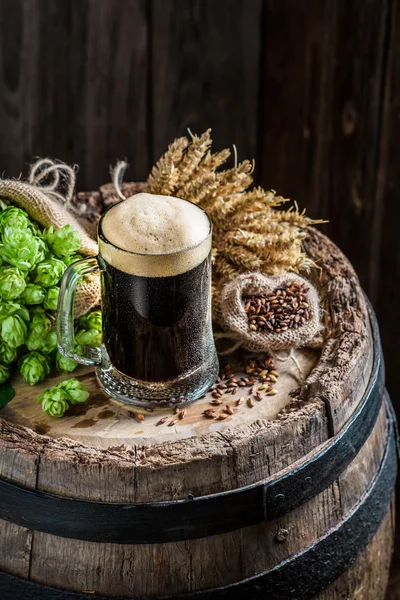 Cold pint of dark beer with ingredients, wheat and hops — Stock Photo, Image