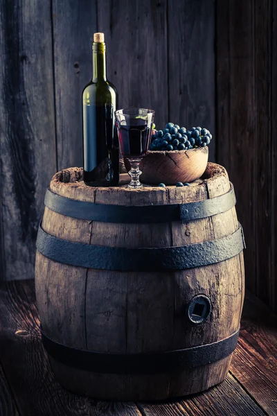 Copo cheio de vinho com uvas frescas em barril de madeira — Fotografia de Stock