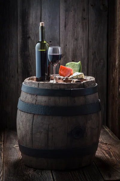 Tasty red wine with mix of cheese on old barrel — Stock Photo, Image