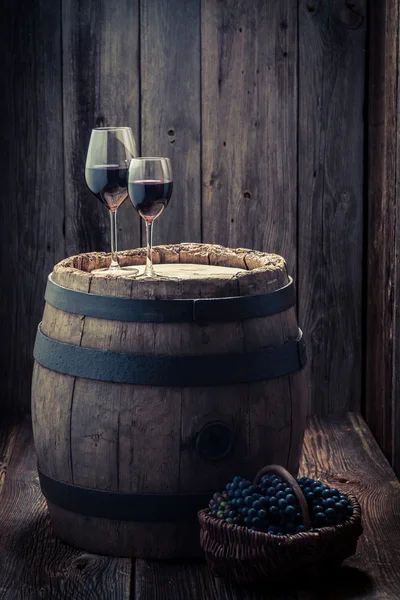 Вкусное красное вино с виноградом и старой деревянной бочкой — стоковое фото