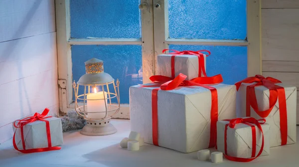 Gifts for Christmas with a frozen window at cold night — Stock Photo, Image