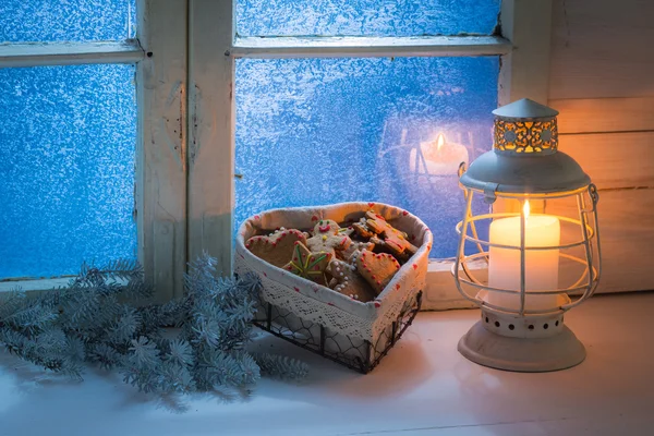 Biscoitos de Natal caseiros por janela congelada com luz de velas — Fotografia de Stock