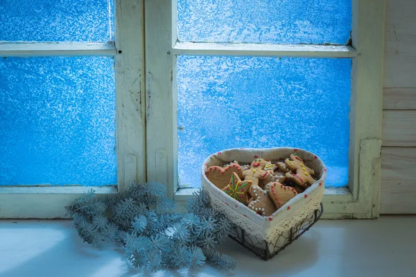 Gingerbread cookies for Christmas by frozen window — Stockfoto