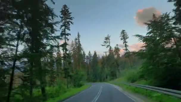 Szybka jazda samochodem na drodze między górami w Tatrach o wschodzie słońca — Wideo stockowe