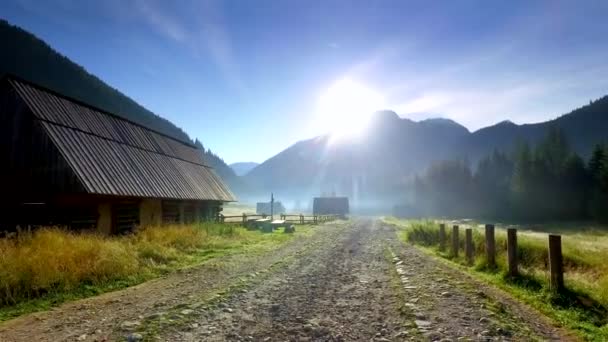 Rotsachtige weg tussen huisjes in de vallei Chocholowska bij zonsopgang, Tatra bergen, Polen — Stockvideo