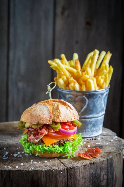 Patatine fritte e deliziosi hamburger a base di pancetta, pomodoro e manzo — Foto Stock