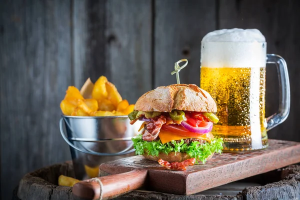Пиво и свежий гамбургер из говядины, сыра и овощей — стоковое фото