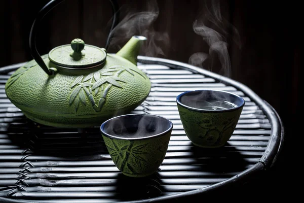 Насладитесь травяным чаем в азиатском ресторане на черном столе — стоковое фото