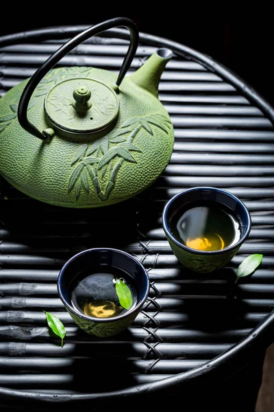 Čerstvé čaje s konvicí na černý stůl — Stock fotografie