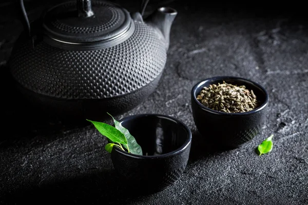 Sabroso té verde con tetera y taza en roca negra —  Fotos de Stock