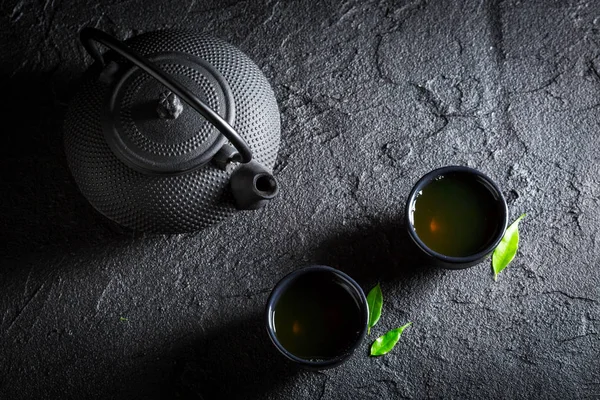 芳香绿茶茶壶与杯黑色岩石上 — 图库照片