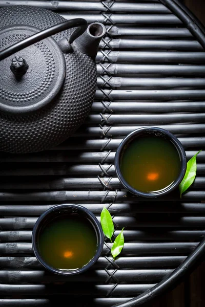 Свежий травяной чай в азиатском ресторане на черном столе — стоковое фото